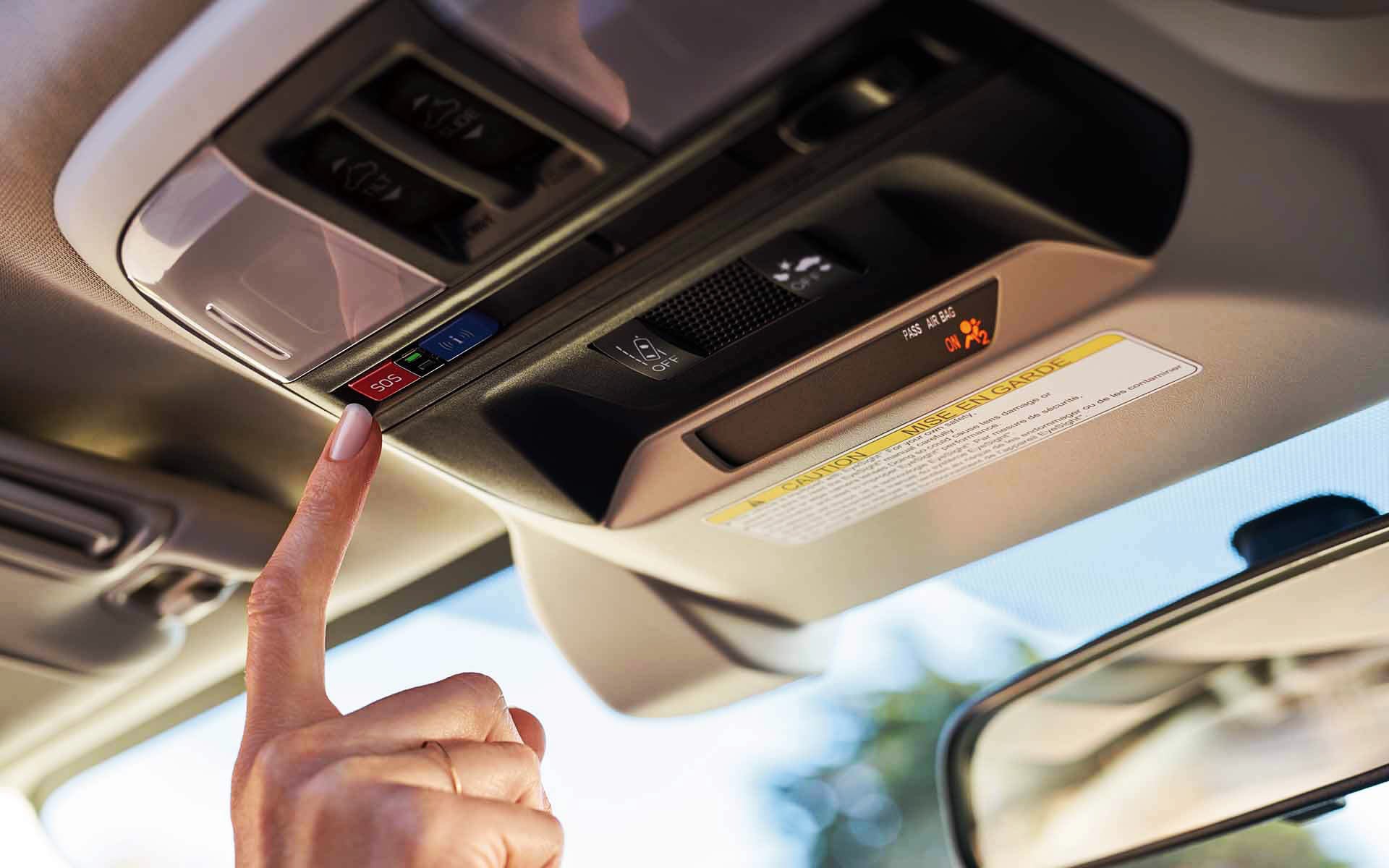 A finger pressing the Crosstrek Hybrid's SOS emergency assistance button | Vann York Subaru in Asheboro NC