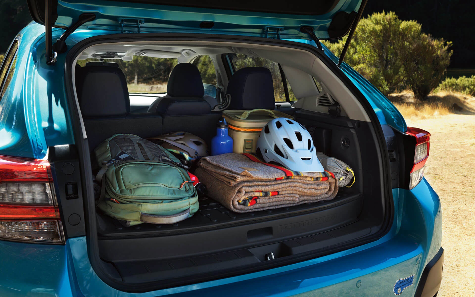 A backpack, blanket, and bike helmet in the rear cargo area of a Crosstrek Hybrid | Vann York Subaru in Asheboro NC